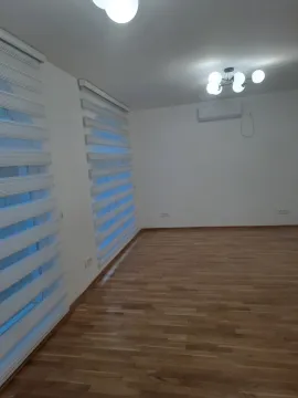 Empty room with laminate flooring and white walls. - image 4