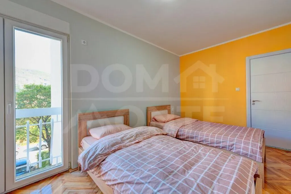 Bedroom with two wooden beds and a balcony access.