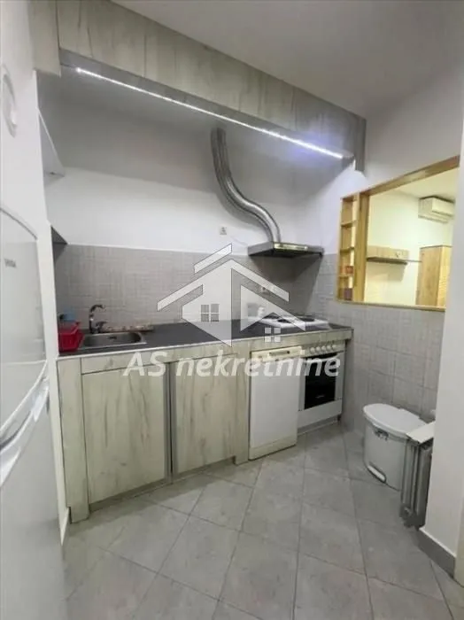 Small kitchen with cabinets, sink, and built-in appliances.
