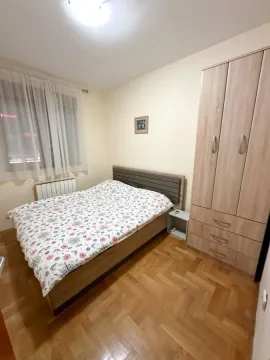 Spavaća soba sa bračnim krevetom, drvenim parketom i ormarom. - image 10