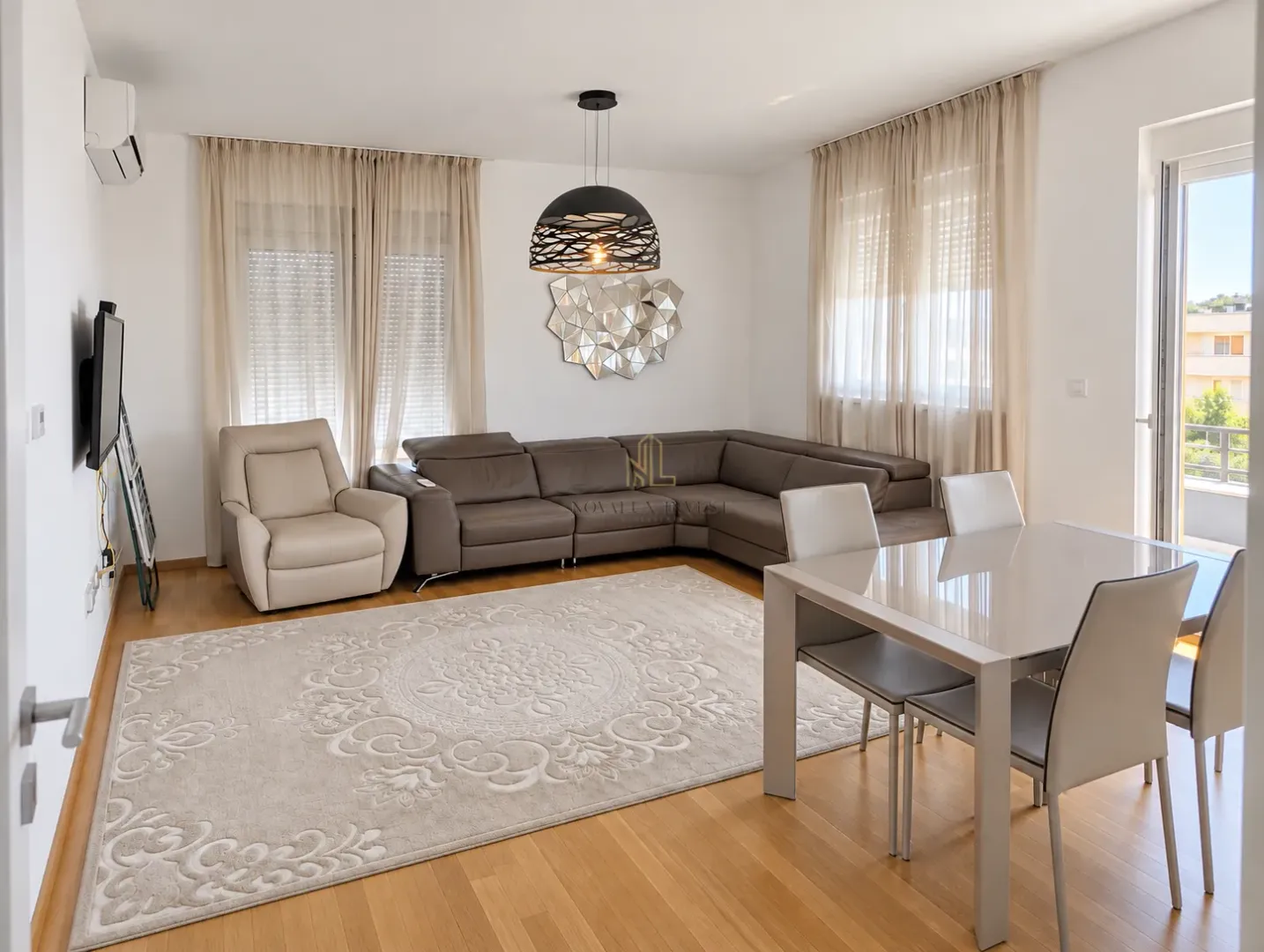 Living room with a sectional sofa, armchair, and dining table.