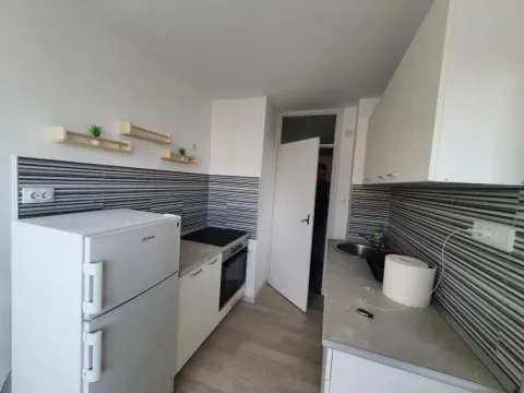 Manja opremljena kuhinja sa belim elementima i frižiderom. - image 8