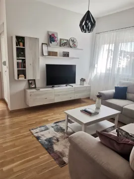 Svijetla dnevna soba sa TV policom i garniturom. - image 2