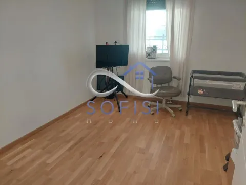 Spavaća soba sa krevetcem, stolom i televizorom. - image 12