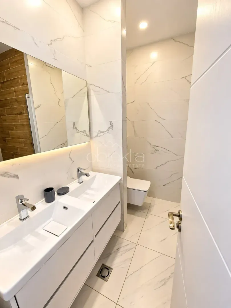 Modern bathroom with double sink and built-in sanitaryware.