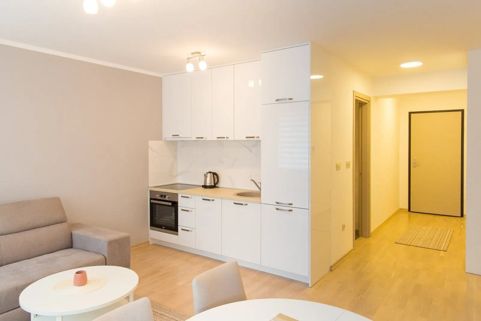Small white kitchen connected to the living room and hallway.