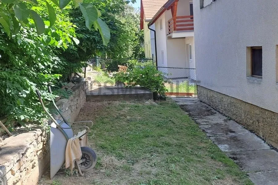 Pogled na dvorište i bočni deo kuće sa stazom.