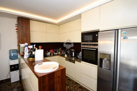 Modern kitchen equipped with built-in appliances and a breakfast bar. - image 8
