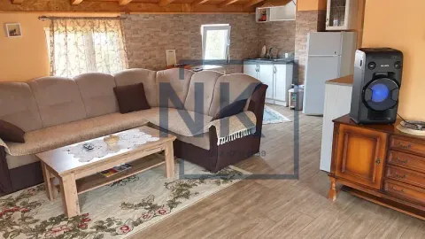 Living room with a sectional sofa, coffee table, and a kitchen area in the background. - image 7