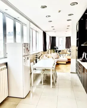 Long kitchen with a dining area and a view of the living room. - image 8