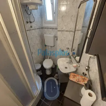 Smaller bathroom with a shower cabin, washbasin, and toilet. - image 9
