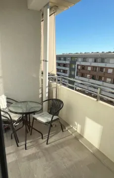 Manji namješteni balkon sa stolom i dve stolice. - image 9