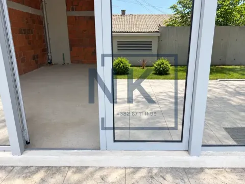 View of the courtyard and exterior space through a glass door. - image 6