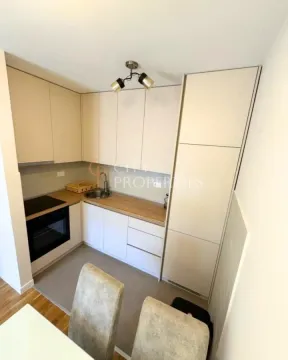 Compact kitchen with white cabinetry and a built-in oven. - image 4
