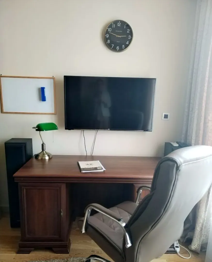 Study room with a desk, chair, and a wall-mounted TV.