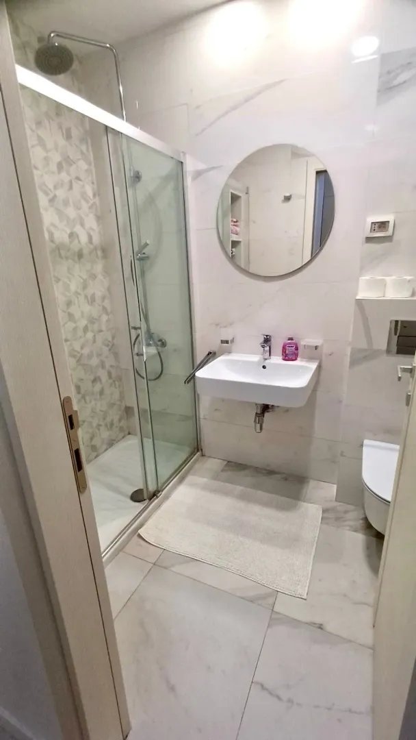 Moderne kupatilo sa tuš kabinom, umivaonikom i WC šoljom.