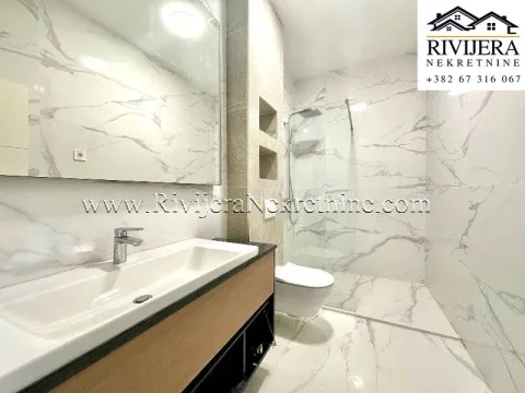Modern bathroom tiled with marble-pattern ceramic tiles and a walk-in shower. - image 9
