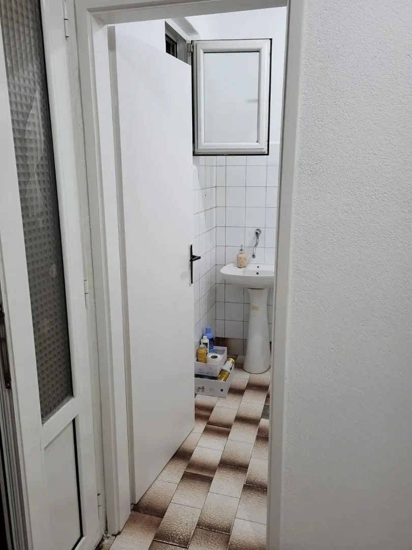 Pogled kroz otvorena vrata na kupatilo sa lavaboom.