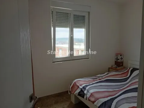 Manja spavaća soba sa krevetom i prozorom koji gleda na okolinu. - image 11