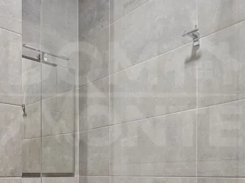 Bathroom detail with grey tiles and a built-in mirror. - image 13