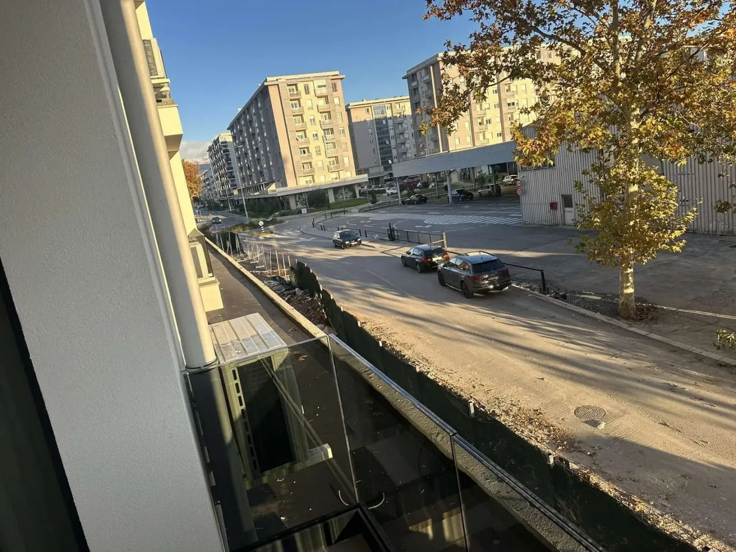 View from the balcony overlooking the street and neighboring residential buildings.