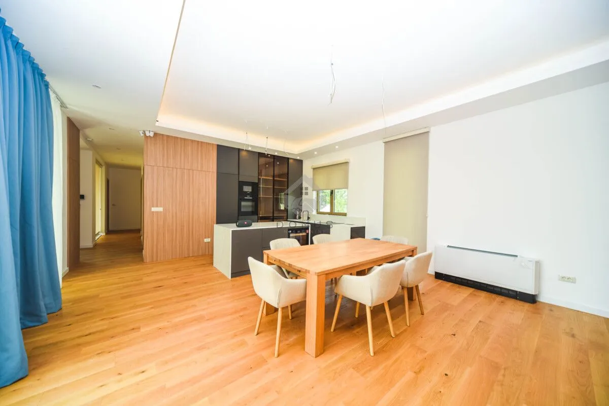 Modern kitchen with a dining area and built-in wooden elements.