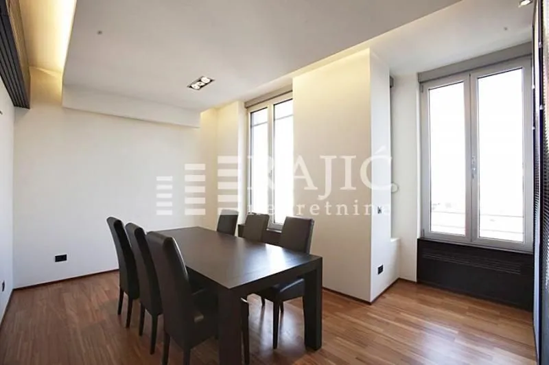 Spacious dining room with a dark wooden table and chairs.