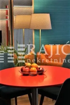 Living room with a dining table and an orange armchair. - image 4