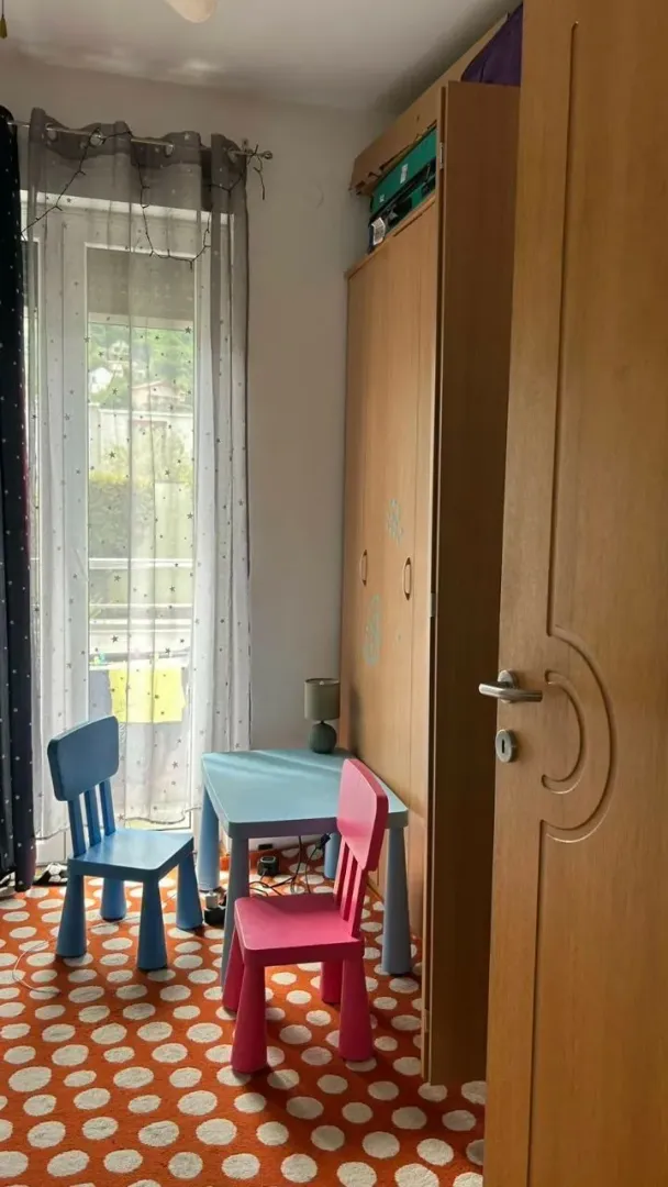 Dječja soba sa ormarom, radnim stolom i stolicama.
