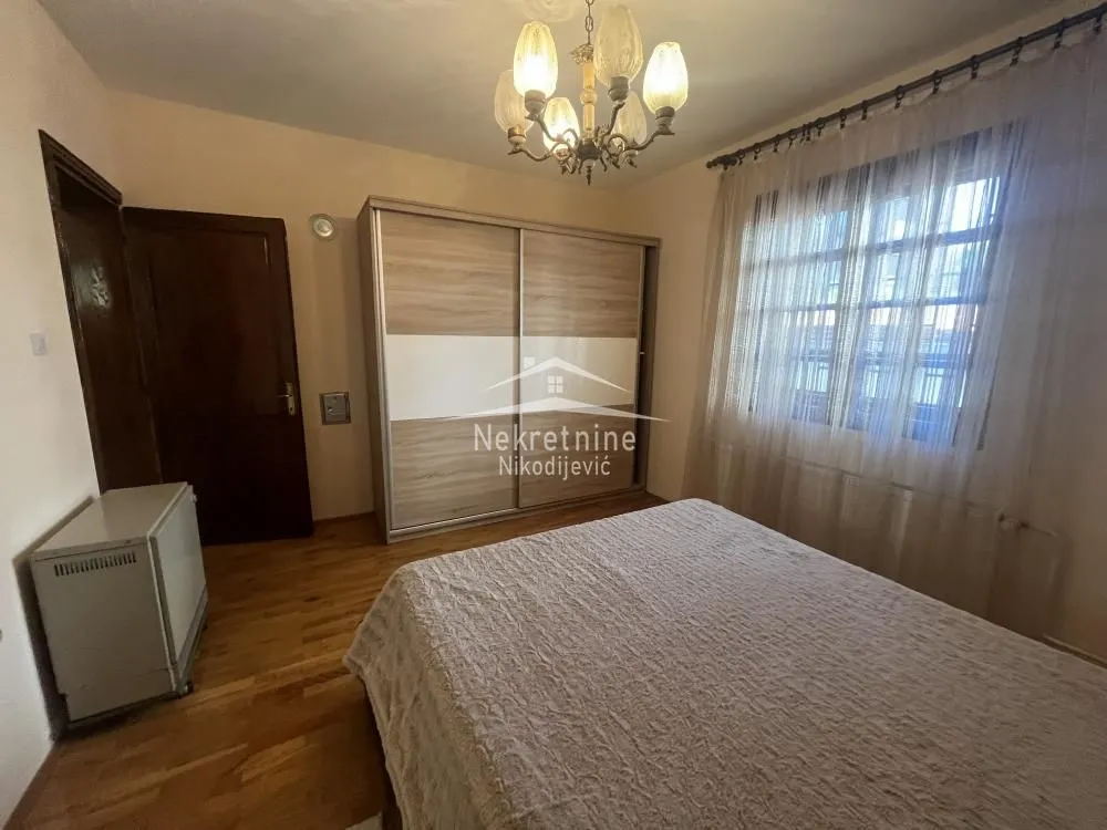 Furnished bedroom with a double bed, large wardrobe, and window.