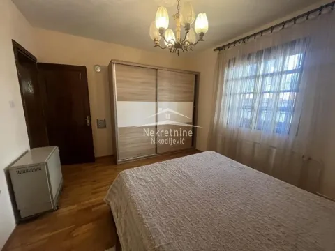 Furnished bedroom with a double bed, large wardrobe, and window. - image 16