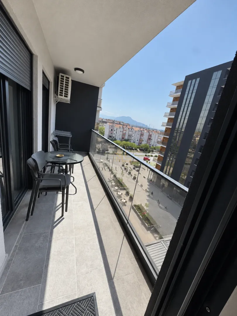 Namješten balkon sa garniturom za sjedenje i pogledom na grad.