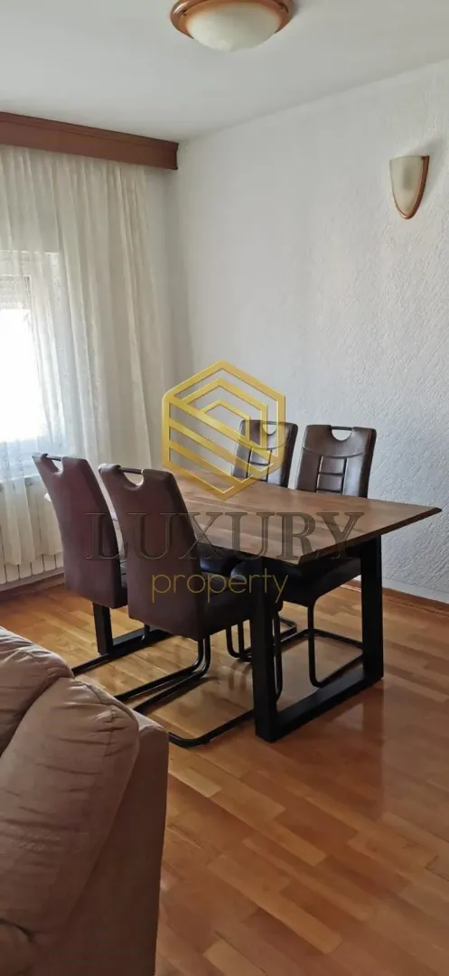 Dnevna soba sa trpezarijskim stolom i stolicama.