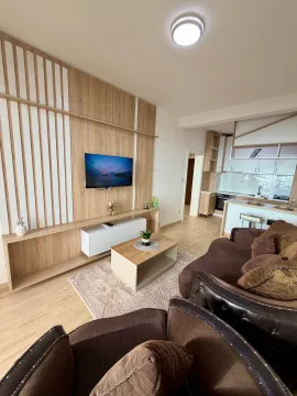 Dnevna soba sa garniturom i drvenim zidnim panelom sa televizorom. - image 4