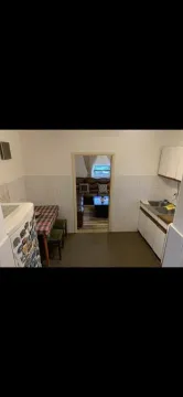 Kitchen with cabinetry and a dining table with a view into the living room. - image 6