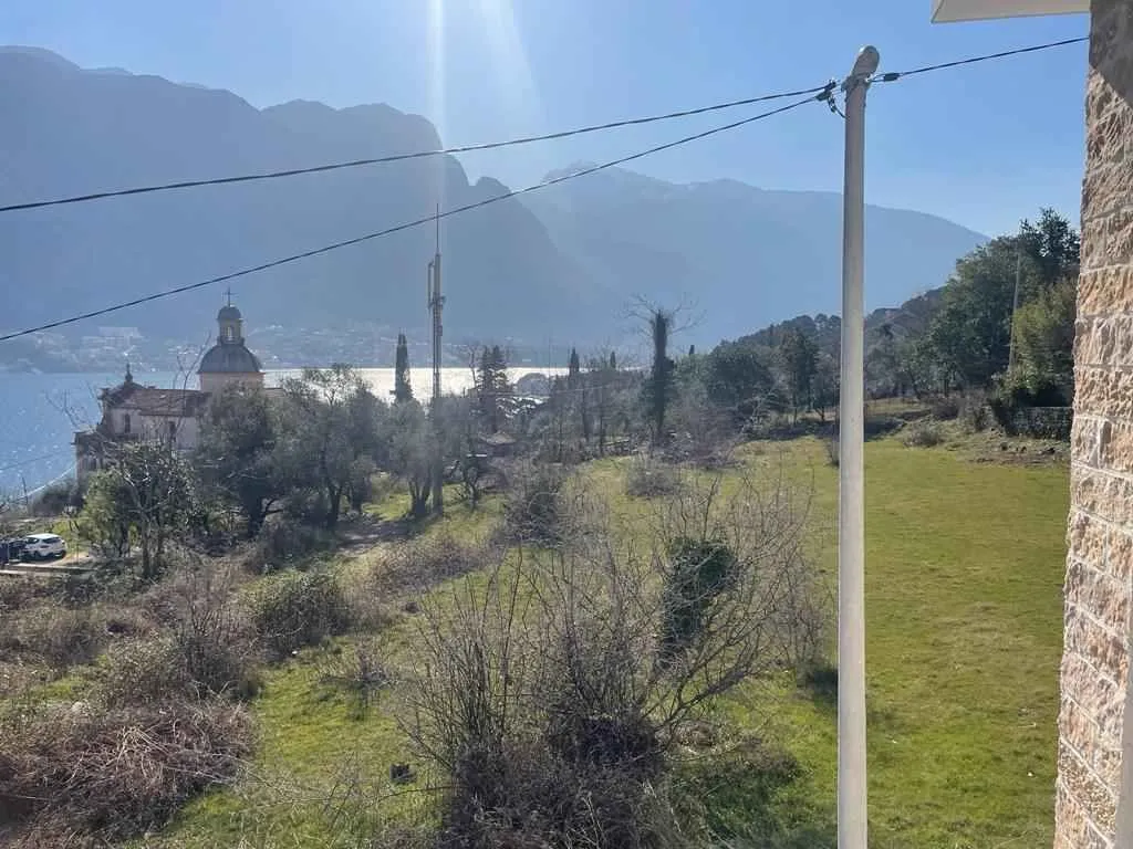 Pogled sa imanja na okolnu prirodu, crkvu i more u daljini.