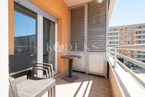 Namješten balkon sa stolom i stolicama i pogledom na okolne zgrade. - image 8