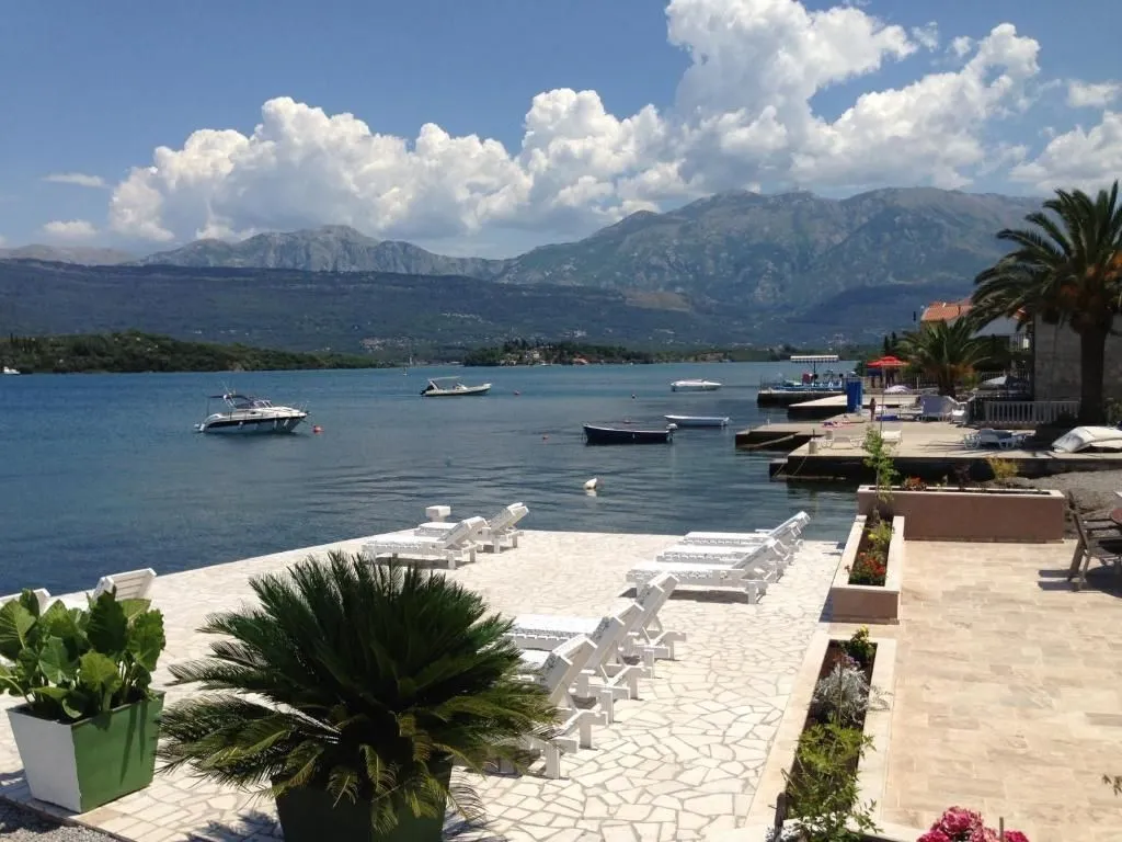Popločana terasa tik uz more sa ležaljkama i pogledom na zaliv.
