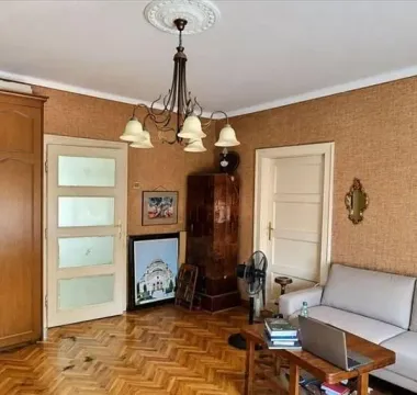 Dnevna soba sa garniturom za sedenje, drvenim podom i tradicionalnim lusterom. - image 18