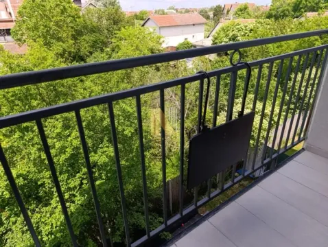 View from the balcony overlooking the green surroundings and nearby houses. - image 10