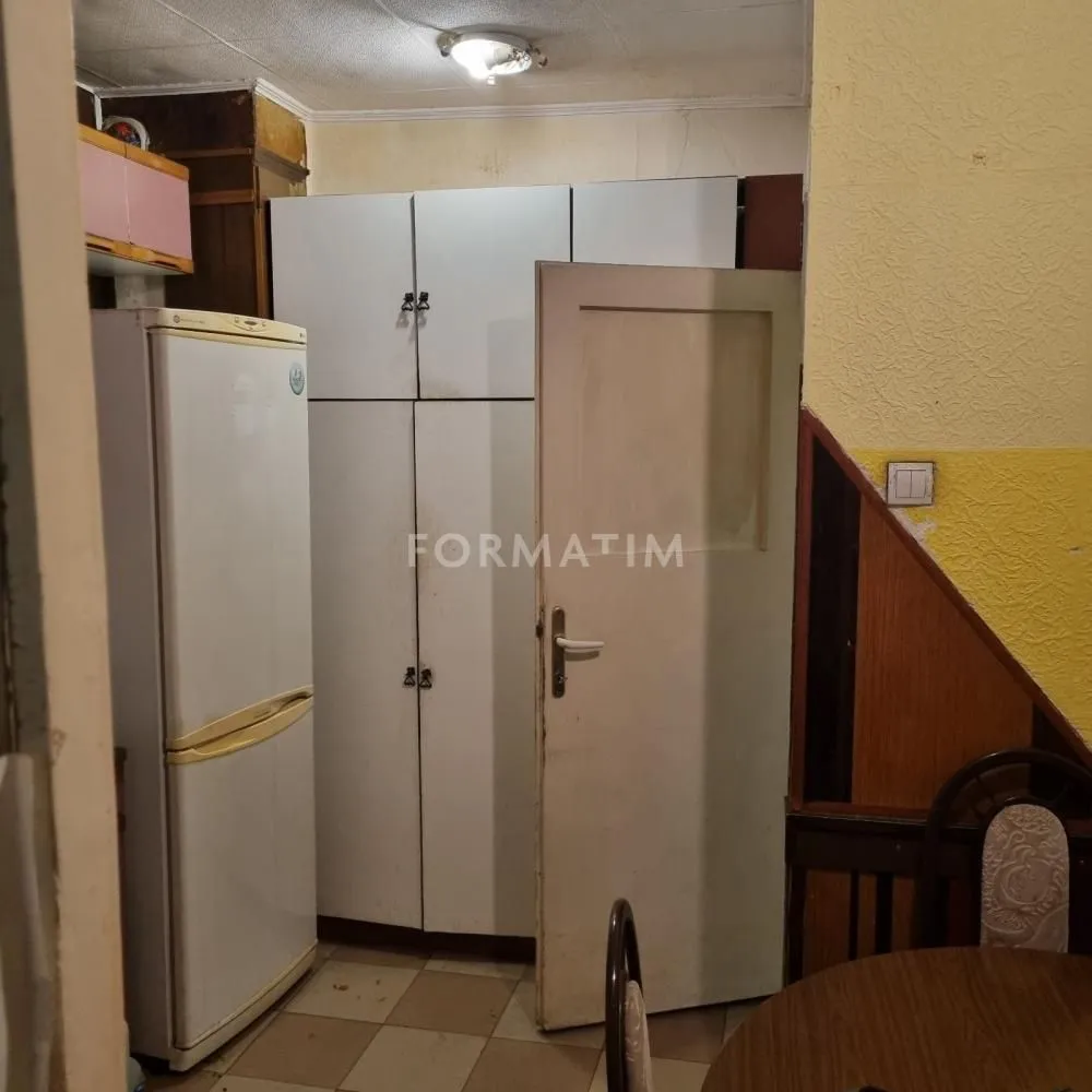Kitchen with a refrigerator, fitted units, and a door.