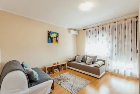 Living room with a sofa seating set and a window with white curtains. - image 6