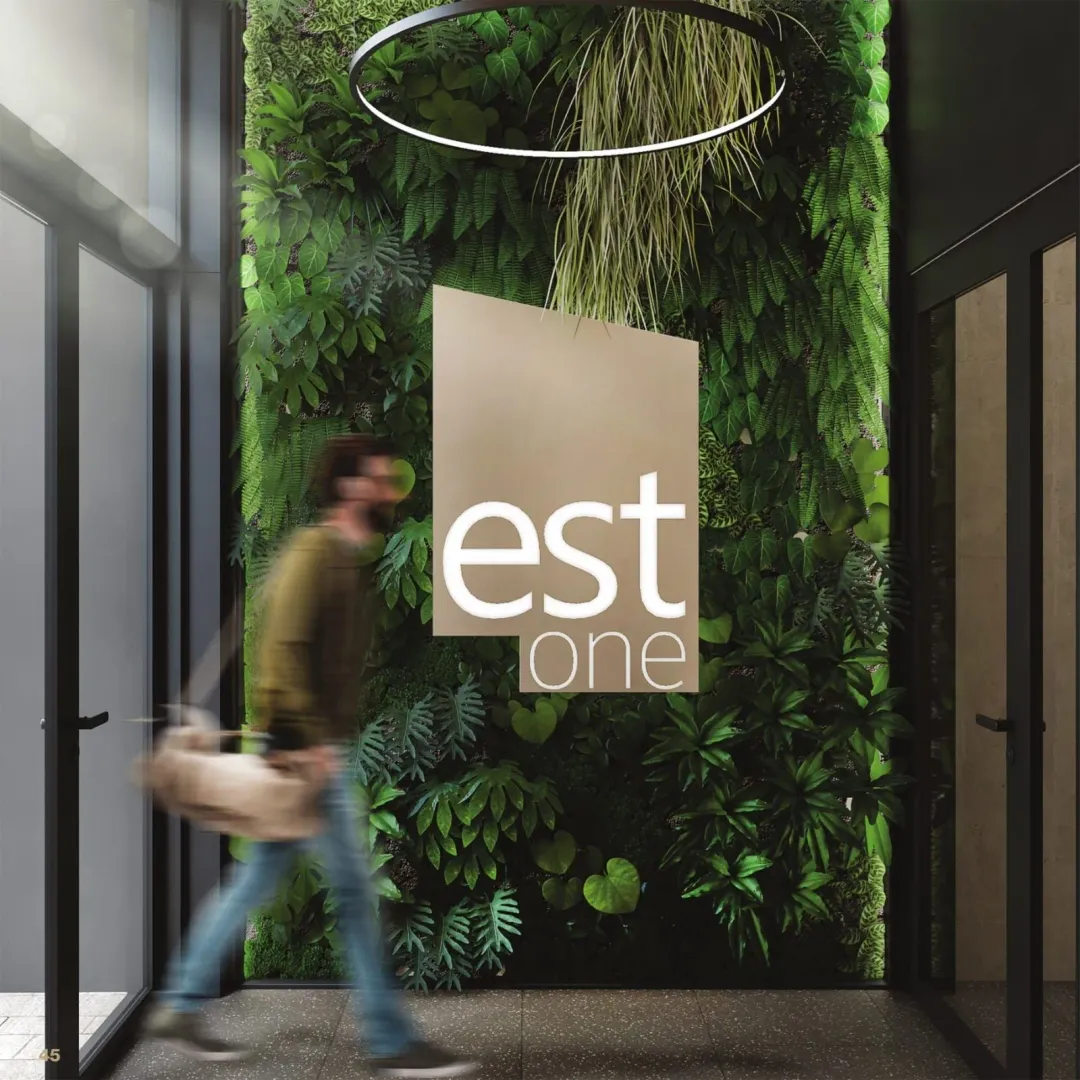 Entrance to a commercial building with a vertical garden and signage.