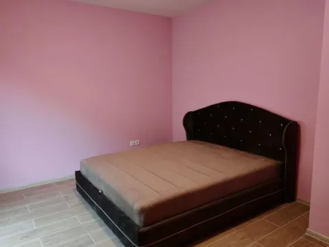 Spavaća soba sa bračnim krevetom i roze zidovima. - image 11