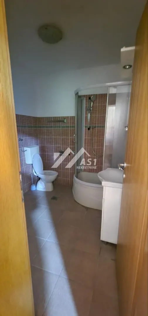 Kupatilo sa tuš kabinom, WC šoljom i umivaonikom.