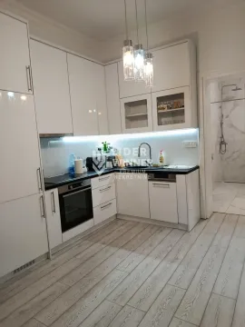 Moderna bela kuhinja sa ugradnim uređajima i pogledom na kupatilo. - image 4