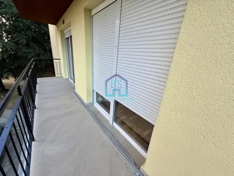 Prostrani balkon sa metalnom ogradom i spoljnim roletnama na prozorima. - image 9