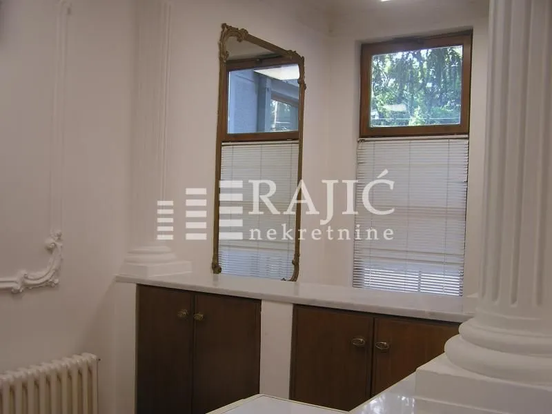 Part of the living room with a mirror and built-in cabinets.