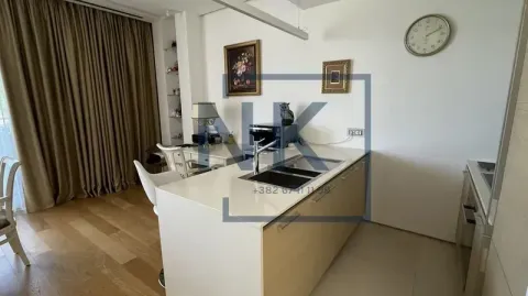 Modern kitchen with an island and sink, opening to the dining area. - image 6