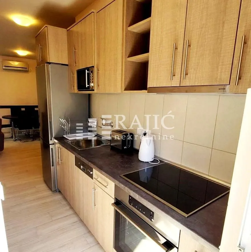 Kitchen with wooden cabinetry and built-in appliances.